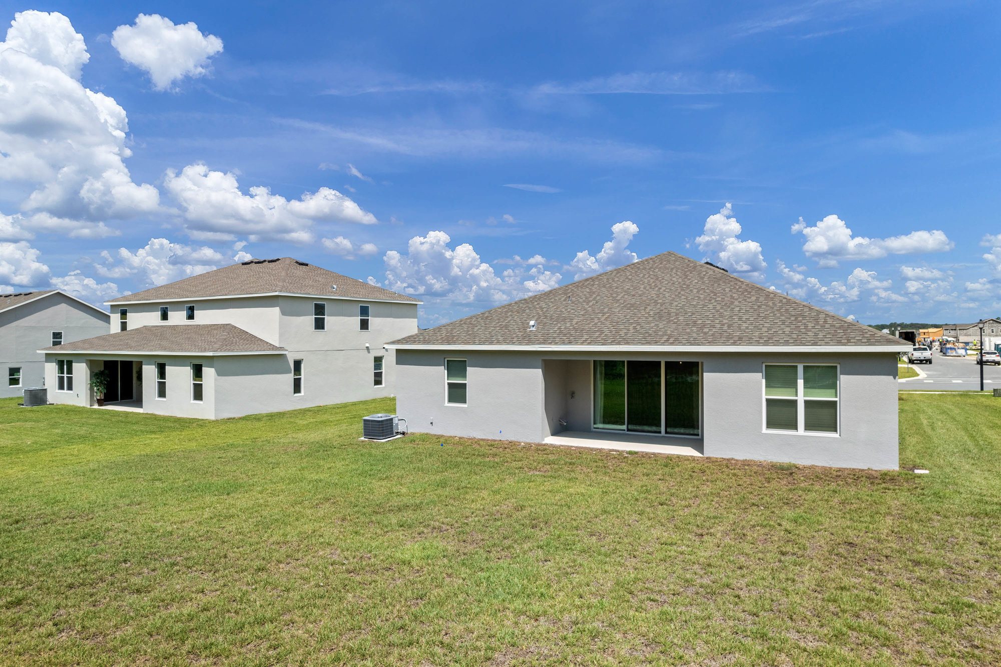 back of home with large back yard and covered lanai
